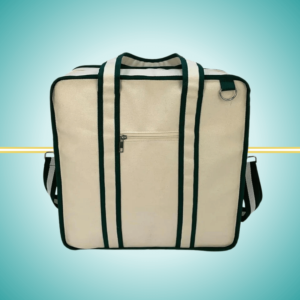 A vintage-inspired tennis tote bag for women, featuring an attached front racket case, an adjustable crossbody strap, and a crisp white design with classic green stripes.