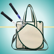 A vintage-inspired tennis tote bag for women, featuring an attached front racket case, an adjustable crossbody strap, and a crisp white design with classic green stripes.