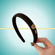 Elegant black headband featuring sophisticated gold metal rose detail