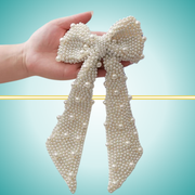 Elegant long white bow hair clip adorned with delicate pearl embellishments, perfect for special occasions or everyday wear.