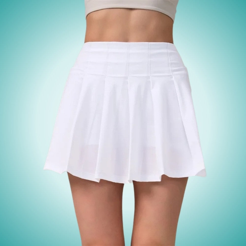 Woman wearing a white  pleated high-waisted tennis skirt with built-in shorts, styled for athletic performance and elegant courtwear.